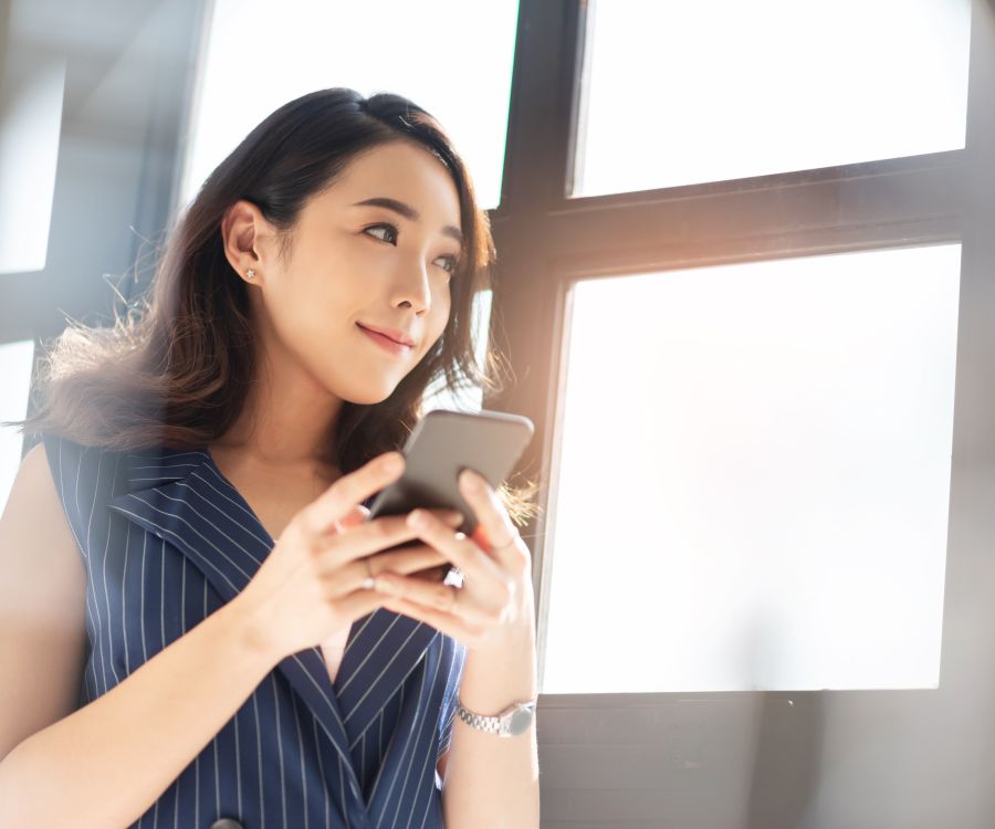 Woman looking very pleased with herself, using mobile phone.