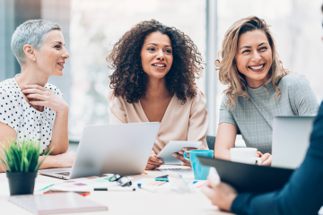 A team of business women enjoying a lively, collaborative meeting.