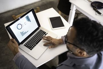 Employee perusing graphicl report output on a laptop screen.