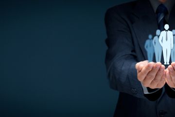 Business man holding vitual projection of male silhouettes in his palms.