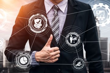 Man giving thumbs up standing in front of virtual projection of symbols and images