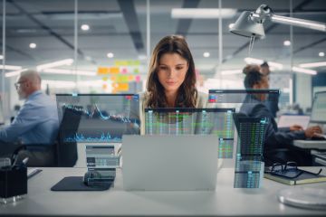 Staff in office with graphs, charts and data overlays.